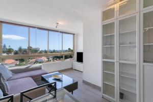 a living room with a couch and a large window at Apartamento Yumbo Maspalomas in Maspalomas