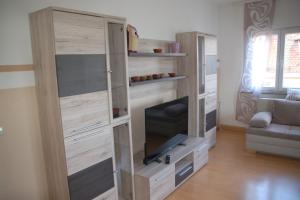 a living room with a large wooden entertainment center with a flat screen tv at Stylische Wohnung in Fellbach in Fellbach