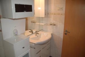 a white bathroom with a sink and a mirror at Stylische Wohnung in Fellbach in Fellbach