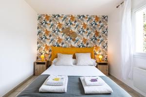a bedroom with a bed with two towels on it at Villa Melchivany - Nature et Océan in Messanges