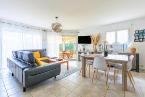 a living room with a couch and a table at Villa Melchivany - Nature et Océan in Messanges