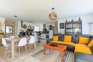 a living room with a couch and a table at Villa Melchivany - Nature et Océan in Messanges