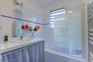 a bathroom with a sink and a mirror and a tub at Villa Melchivany - Nature et Océan in Messanges +21 photos