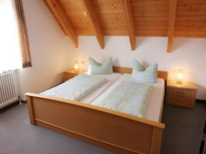 two beds in a room with wooden ceilings and two lamps at Sommerhof Rauber in Immenstaad am Bodensee