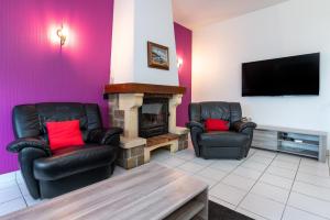 a living room with two chairs and a fireplace at Maison entre terre et mer in Pluvigner