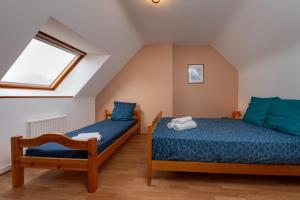 a attic bedroom with two beds and a window at Maison entre terre et mer in Pluvigner