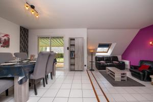 a living room with purple walls and a dining room at Maison entre terre et mer in Pluvigner