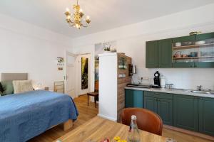 a bedroom with green cabinets and a bed and a kitchen at Schlafen im historischen Haus in Weier