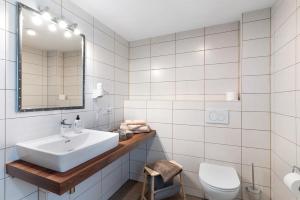 a white bathroom with a sink and a toilet at Urlaub Im Kulturdenkmal in Alpirsbach +17 photos