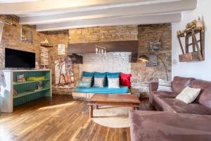 a living room with a couch and a stone wall at Longère 5min de Pont-Aven in Riec-sur-Bélon