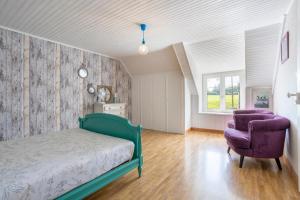 a bedroom with a bed and a purple chair at Longère 5min de Pont-Aven in Riec-sur-Bélon