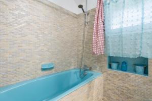 a bathroom with a blue tub and a window at Longère 5min de Pont-Aven in Riec-sur-Bélon +19 photos