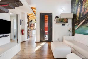 a living room with a white couch and a tv at Cinque terre - Laspezia - Loft 1910 in La Spezia