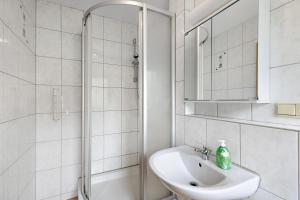 a white bathroom with a sink and a shower at Hotel Neue Krone - Markt Erlbach in Markt Erlbach +41 photos