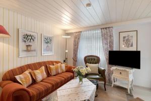 a living room with a couch and a tv at Haus Haag Enzklösterle in Enzklösterle