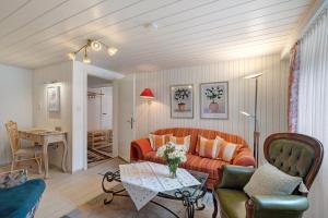 a living room with an orange couch and a table at Haus Haag Enzklösterle in Enzklösterle