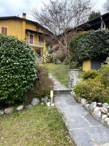 a garden with a stone path in front of a house at Home Pier in Laveno-Mombello