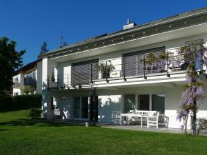 a white building with a table and chairs in a yard at Ferienwohnung Peterberg 22, 45qm in Kirchzarten