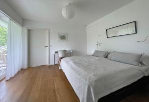 a white bedroom with a bed and a window at Ferienwohnung Peterberg 22, 45qm in Kirchzarten
