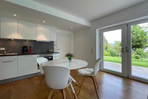 a kitchen with a white table and white chairs at Ferienwohnung Peterberg 22, 45qm in Kirchzarten