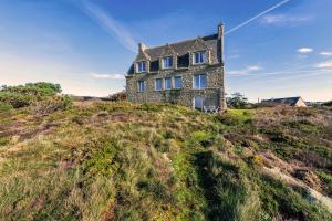 an old stone house on a hill on the beach at Studio vue sur mer in Plomodiern