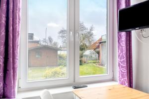 a room with two windows with purple curtains at Kleine Himmelpforte in Himmelpforten