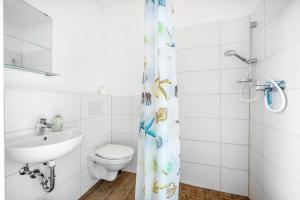 a white bathroom with a toilet and a sink at Kleine Himmelpforte in Himmelpforten