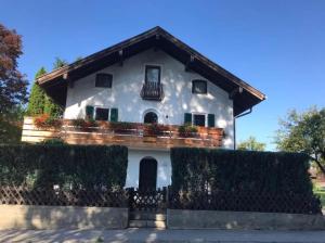 a white house with a balcony at Chiemsee Schwanenloft in Seebruck