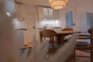 a kitchen with a table and chairs in a kitchen at Chiemsee Schwanenloft in Seebruck +8 photos