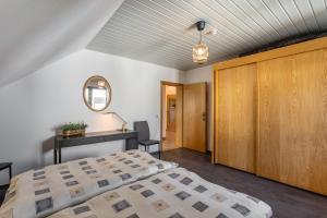 a bedroom with a bed and a desk and a mirror at Vista-Homert in Eslohe