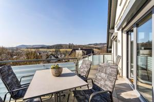 a patio with a table and chairs on a balcony at Vista-Homert in Eslohe