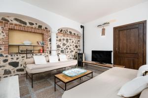a living room with two beds and a tv at Villa Pedduzza in Orosei