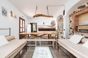 a kitchen and dining room with a wooden table and benches at Villa Pedduzza in Orosei