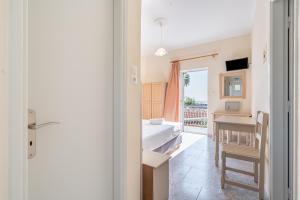 a room with a bathroom with a table and a sink at Alex bar apartments in Parga