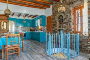 a kitchen with blue cabinets and a stone wall at Archontiko Keli in Katákoilos +23 photos