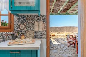 a kitchen with blue cabinets and a view of a patio at Archontiko Keli in Katákoilos