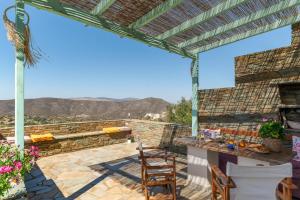 a patio with a pergola and a table and chairs at Archontiko Keli in Katákoilos