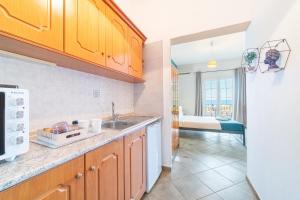 a kitchen with a sink and a room with a bed at Spyridoula Studio 4 in Paleokastritsa