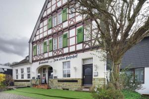 a large white building with green shutters at Tati's Ferienwohnung Siegerland in Hilchenbach