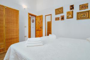 a bedroom with a white bed with towels on it at Casa Asfodeli in San Teodoro