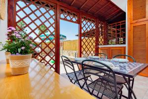 a table with chairs and a vase of flowers on a patio at Casa Asfodeli in San Teodoro