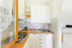 a white kitchen with white cabinets and a sink at Villaggio Colombo V5 in Marina di Andora