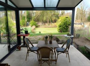 a table and chairs on a patio with a view at Chambres D'hôtes Les Préaux - in Cérans-Foulletourte