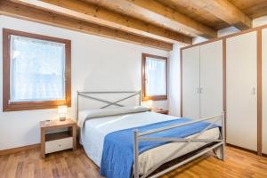 a bedroom with a bed and two windows at Casa Giuly in Mirano