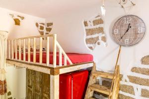 a room with a bunk bed and a clock on the wall at Tipica casa a San Pantaleo in San Pantaleo