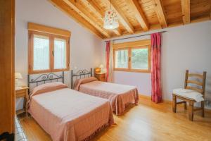 a bedroom with two beds and a chair at Los Molinillos in Caballar