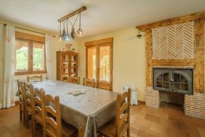 a dining room with a table and a fireplace at Los Molinillos in Caballar