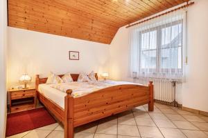 a bedroom with a bed and a large window at Ferienhaus Behler in Kressbronn am Bodensee