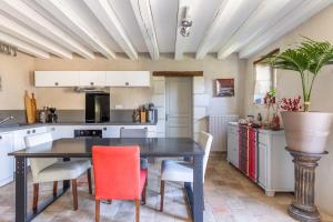a kitchen with a black table and chairs at Au Bo Voyage in Tavant