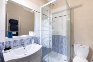 a bathroom with a toilet and a sink and a shower at Au Bo Voyage in Tavant